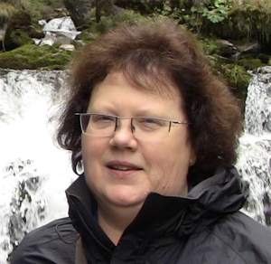 Portrait of Pastor Beth Hoskins standing by a waterfall